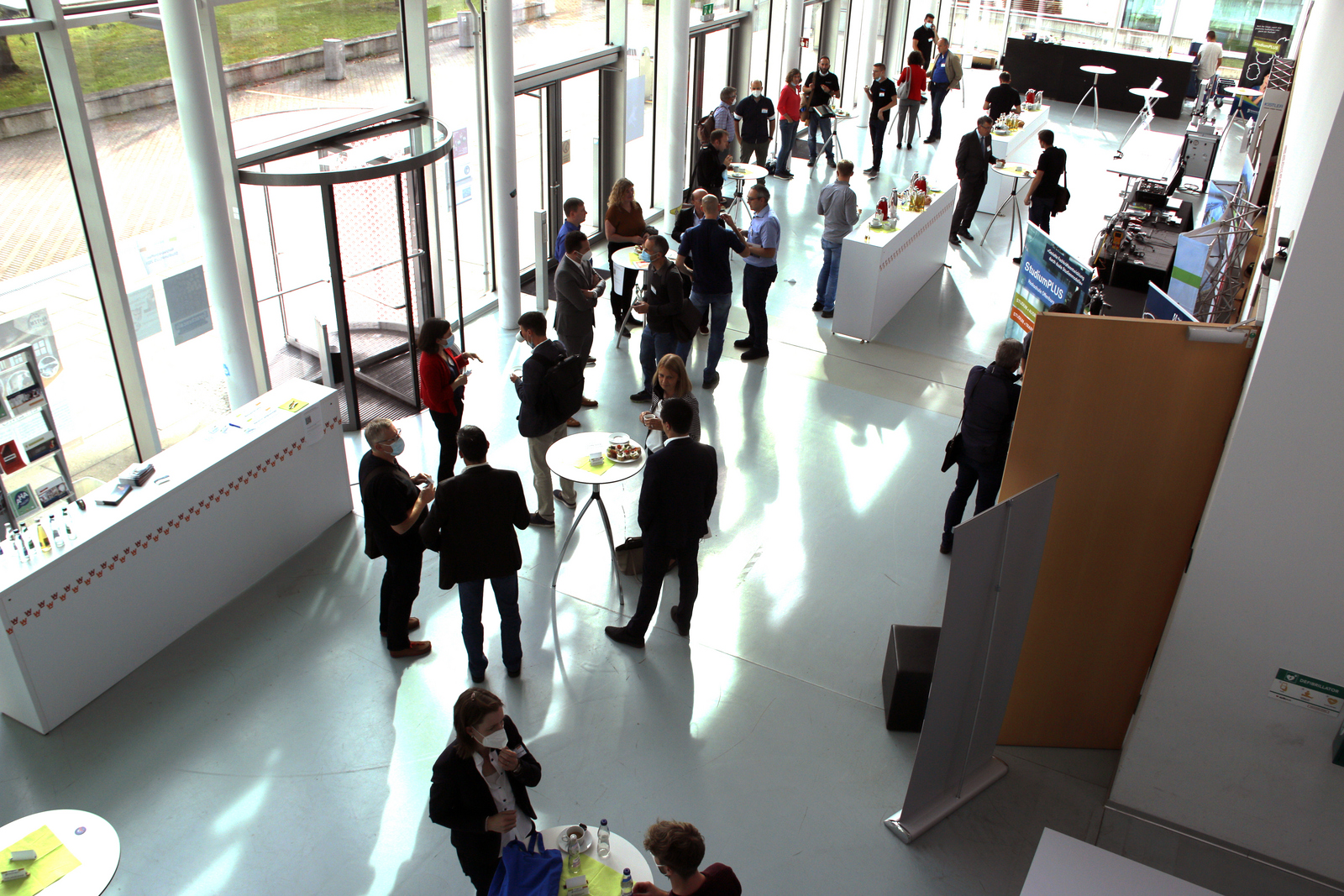 Netzwerktreffen StudiumPLUS 2021: Teilnehmer an Stehtischen im Foyer des D-Gebäudes